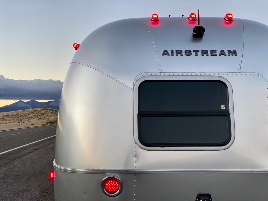 Graphic depicting a mountain peak at sunset cropped in a circle with the words RANGE CRAZY above and below.